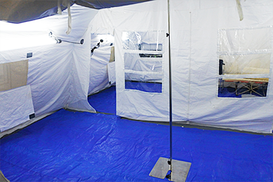 仕切り幕でテント内を2つのゾーンに分けることで医療従事者の飛沫感染に配慮